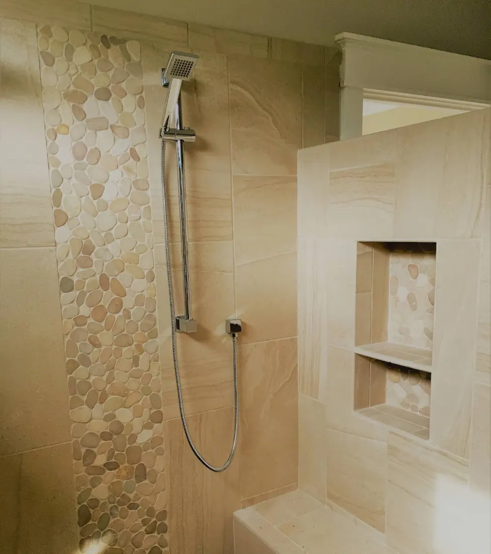 Shower with natural stone tile and pebble accent column